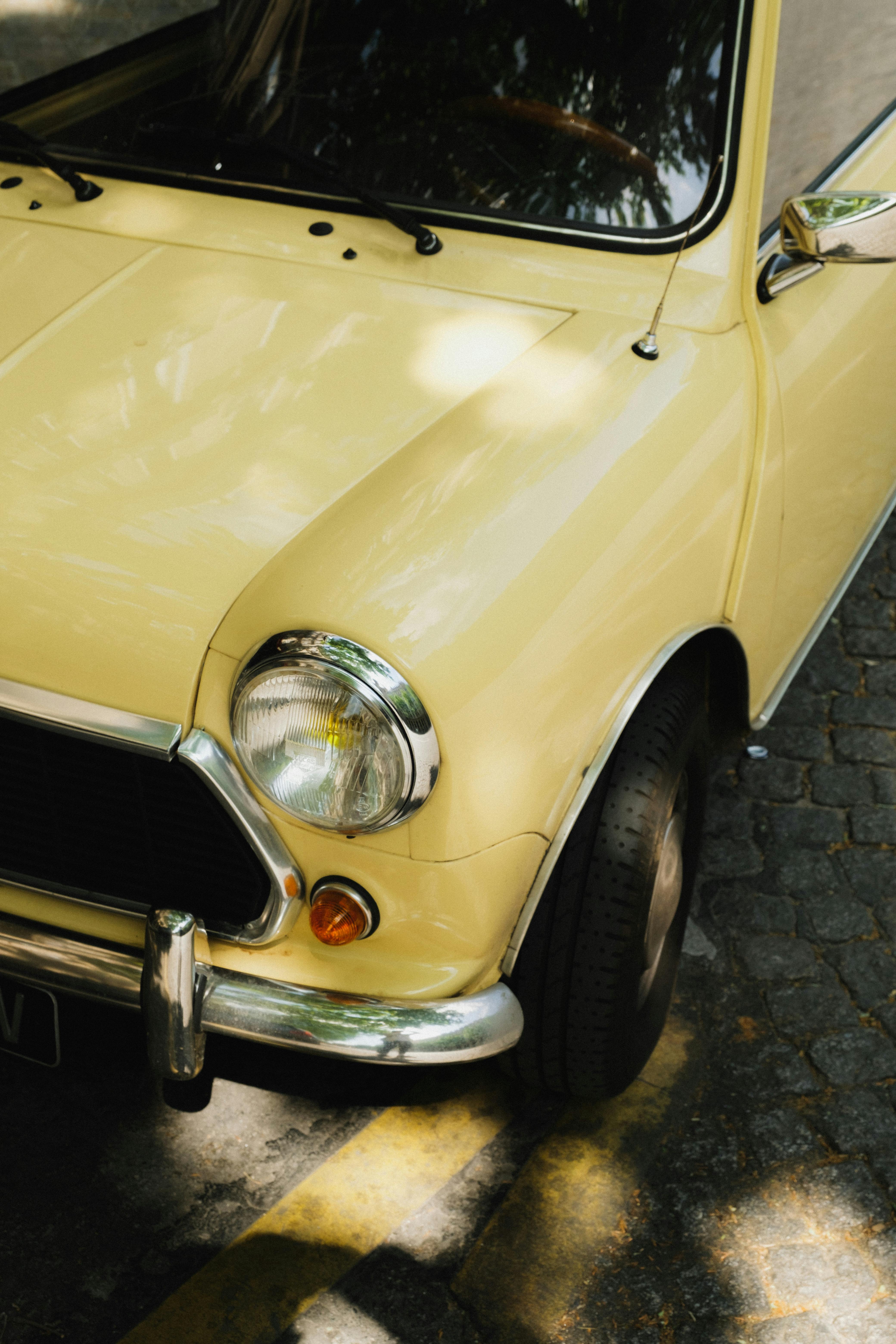 Close-up of a yellow classic vintage car on a sunny day.