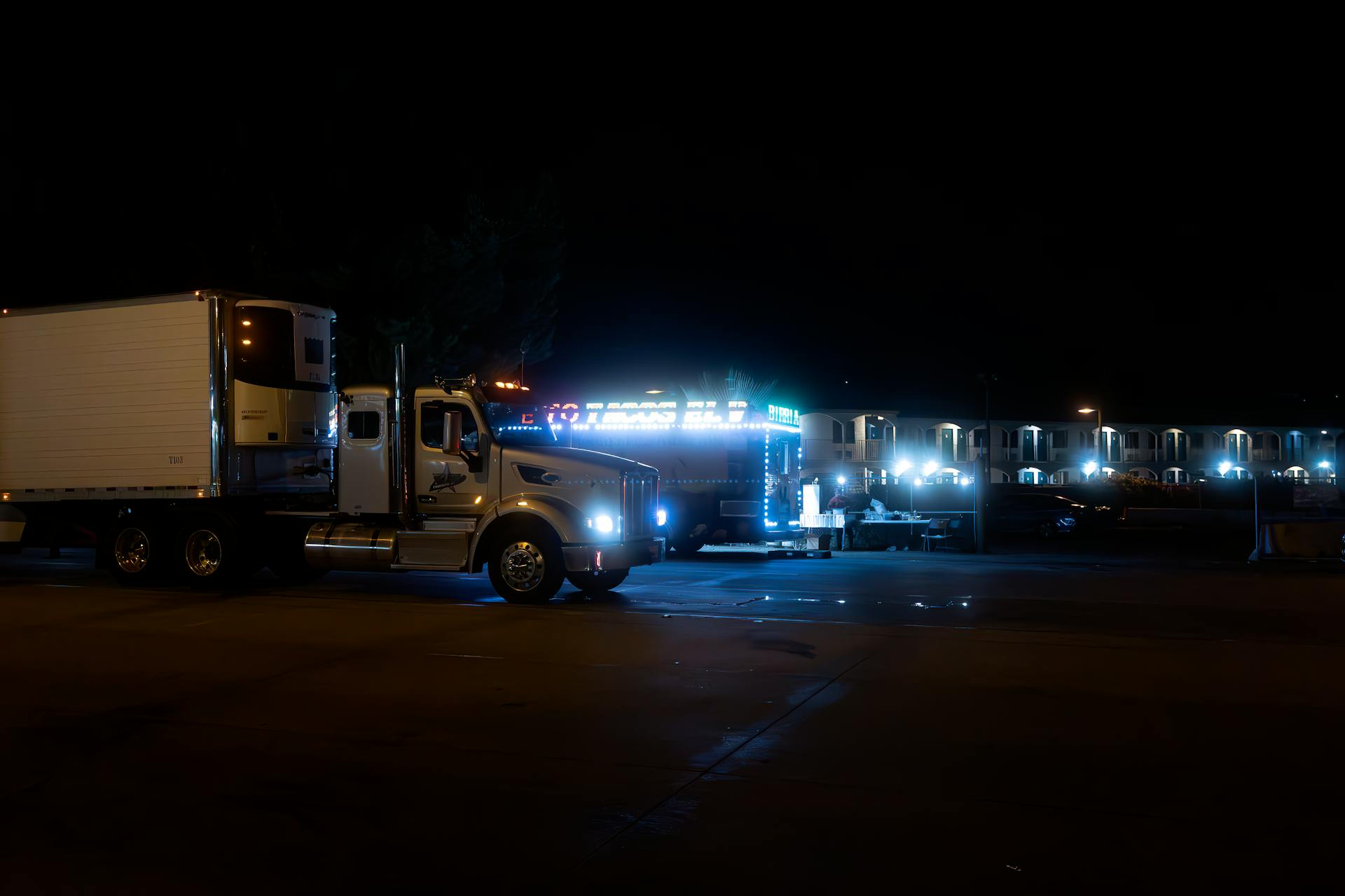 A truck is parked at night with lights on