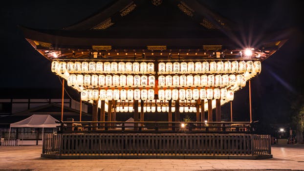 Brightly lit lanterns in a Kyoto shrine create a magical nighttime ambiance.