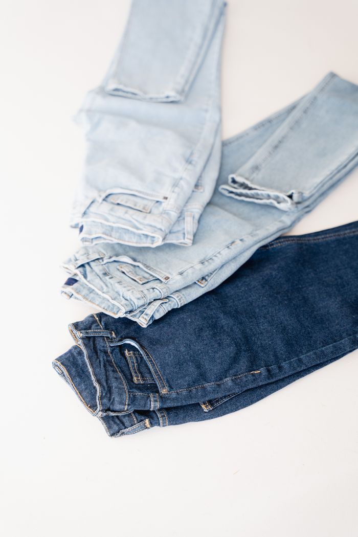 Folded denim trousers in light and dark washes, photo by Dmitriy Steinke on Pexels