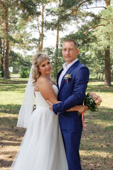 Bride and groom embracing in a natural outdoor setting, exuding love and happiness.