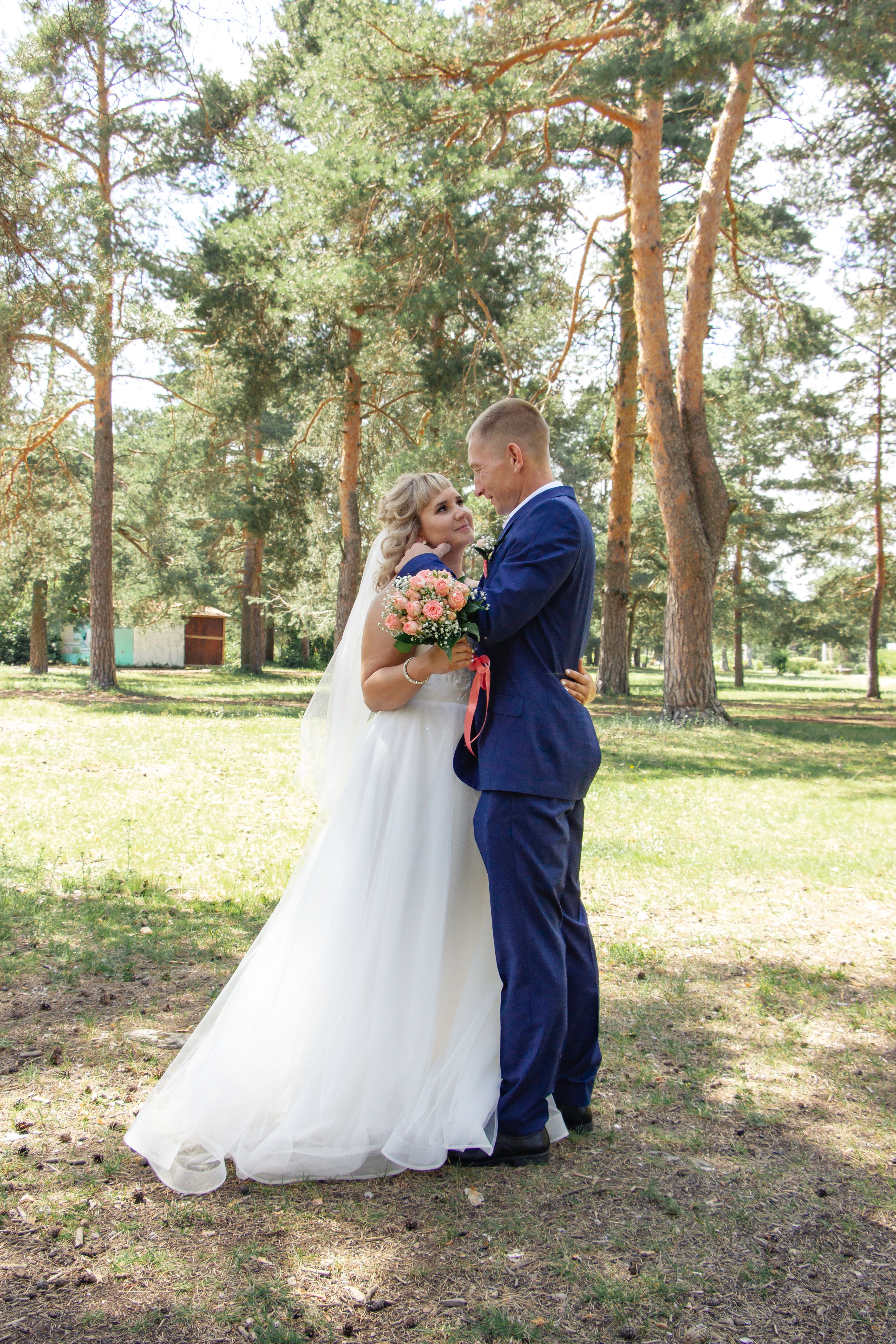 A bride and groom standing in the woods · Free Stock Photo