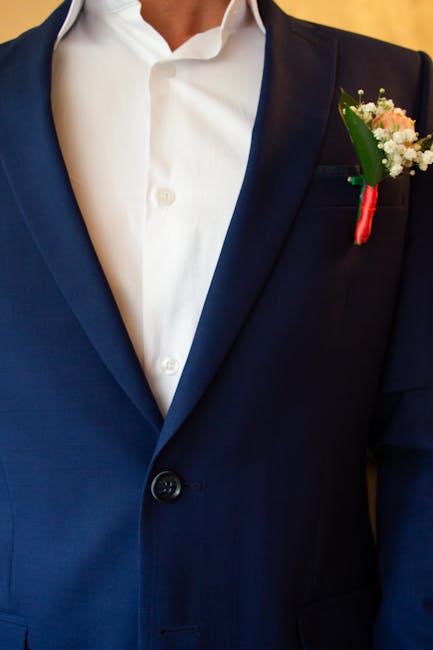 Close-up of a groom in a blue suit with a floral boutonniere, perfect for weddings and ceremonies.