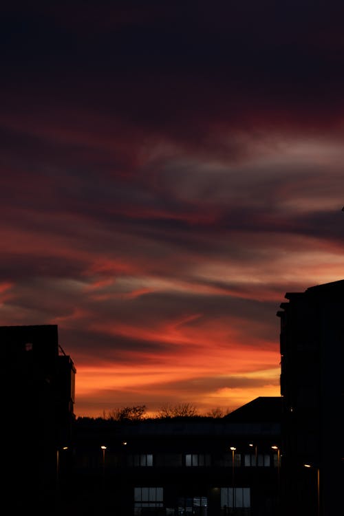 Silhouetted Buildings in City under a Dramatic Sunset Sky 