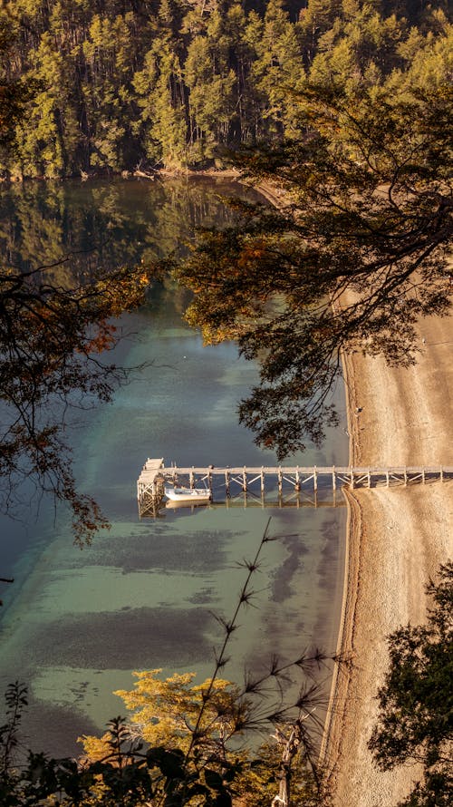 Aerial View of a Pier with a Moored Boat on a Body of Water 