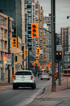 Downtown view of city traffic at an intersection flanked by skyscrapers.