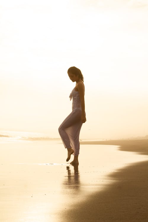 Woman Posing on Sea Shore at Sunset