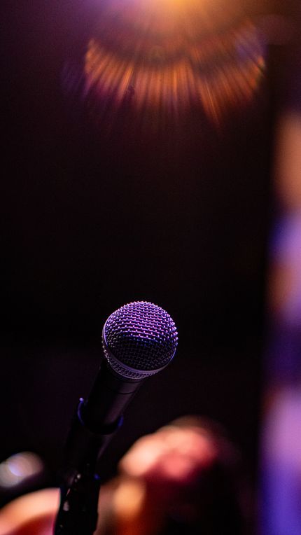 Microphone under a warm spotlight — photo by Karla De León on Pexels