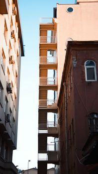 A contemporary urban building with a fire escape staircase against a blue sky.