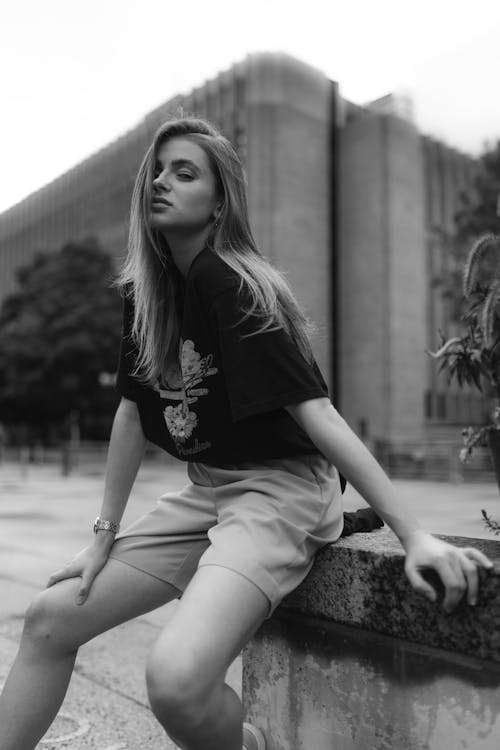 Woman Sitting on a Wall on a Street in Black and White 