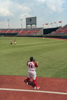 Baseball players warming up in an empty stadium on a clear day.