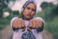 Panning Photography of Woman Raising Her Hands With Viva and Vida Tattoos
