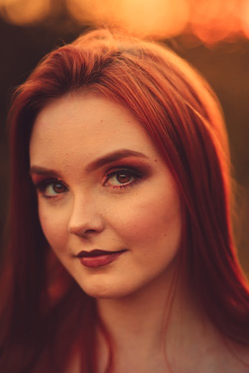 Redhead woman with bright makeup looking at camera