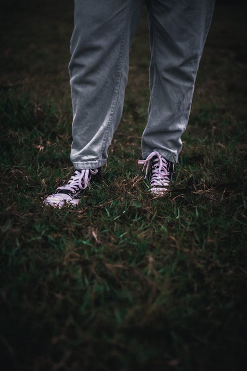 Man Wearing Jeans and Sneakers on a Field 