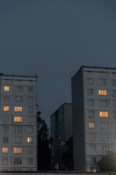Dark urban scene with lit apartment windows during twilight. Perfect for city architecture themes.