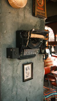 A retro typewriter mounted on a textured wall in a cozy vintage interior, evoking nostalgia.