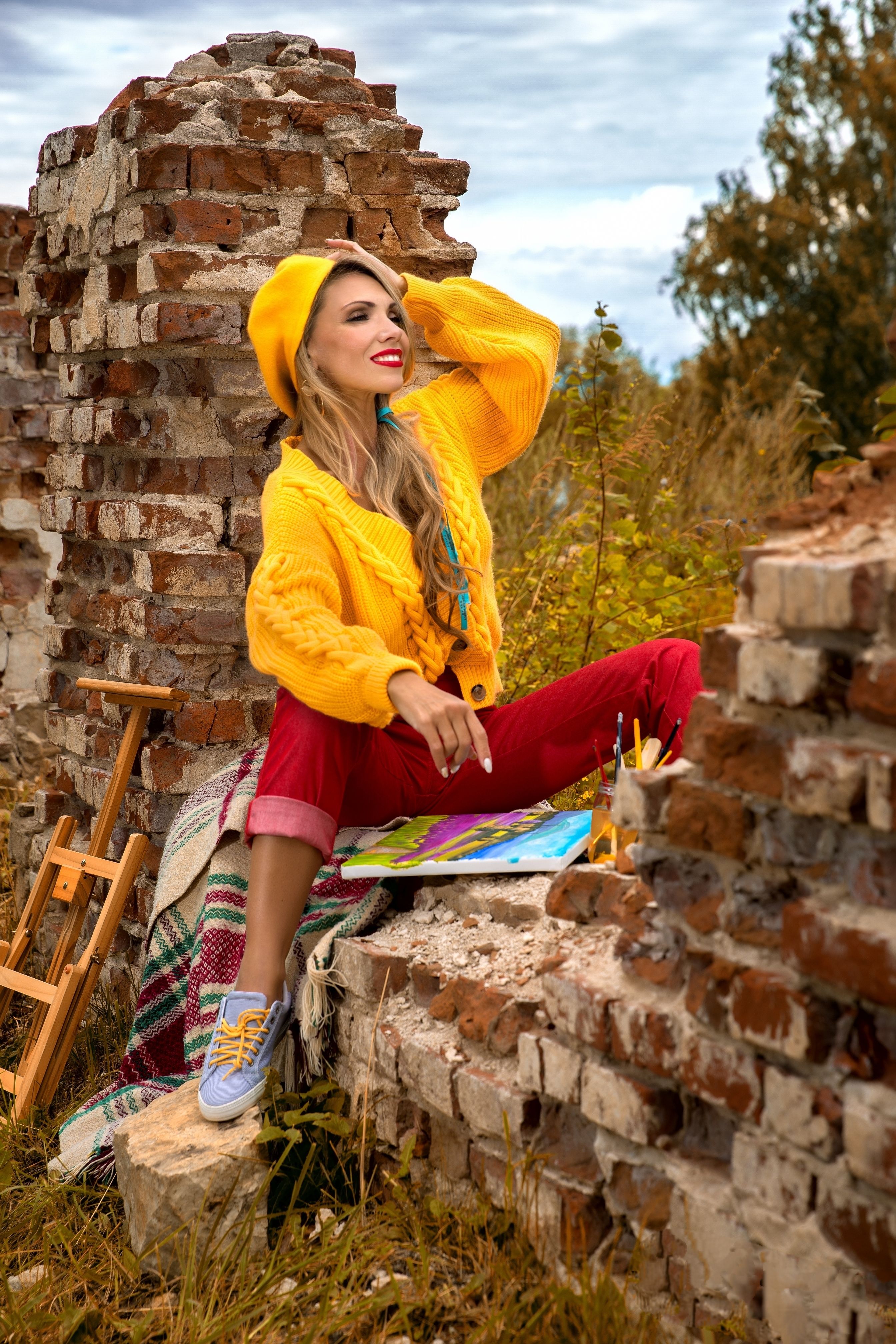 A woman in yellow jacket sitting on a brick wall · Free Stock Photo