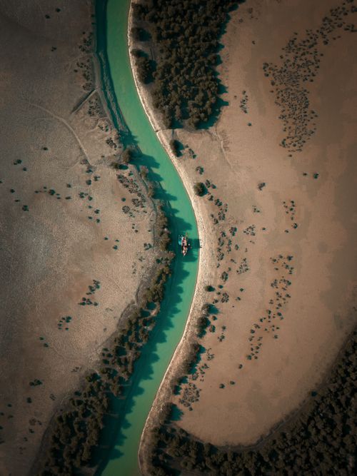 Free Drone shot capturing a winding river and surrounding arid landscape in Hormozgan Province, Iran. Stock Photo
