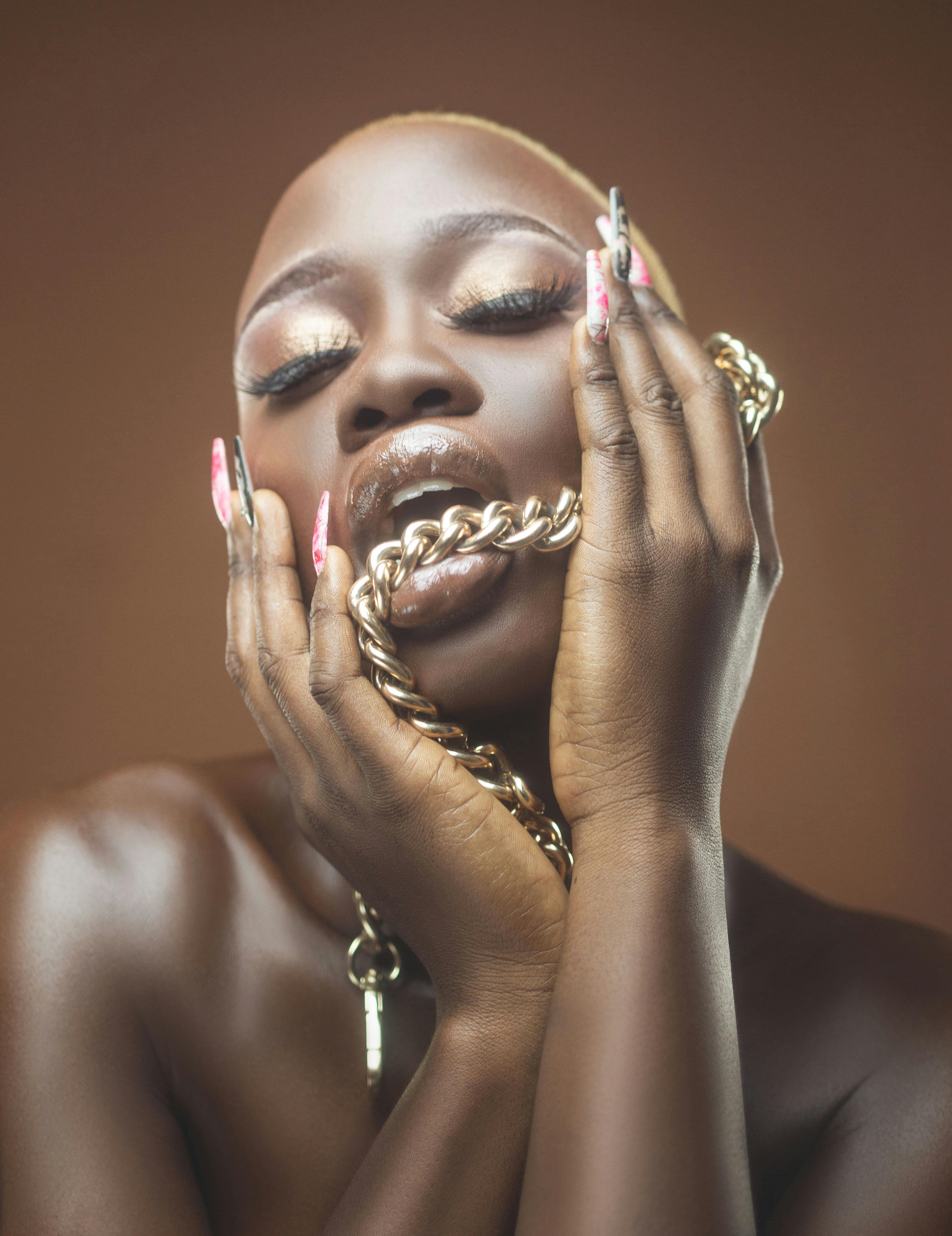 woman biting golden chain