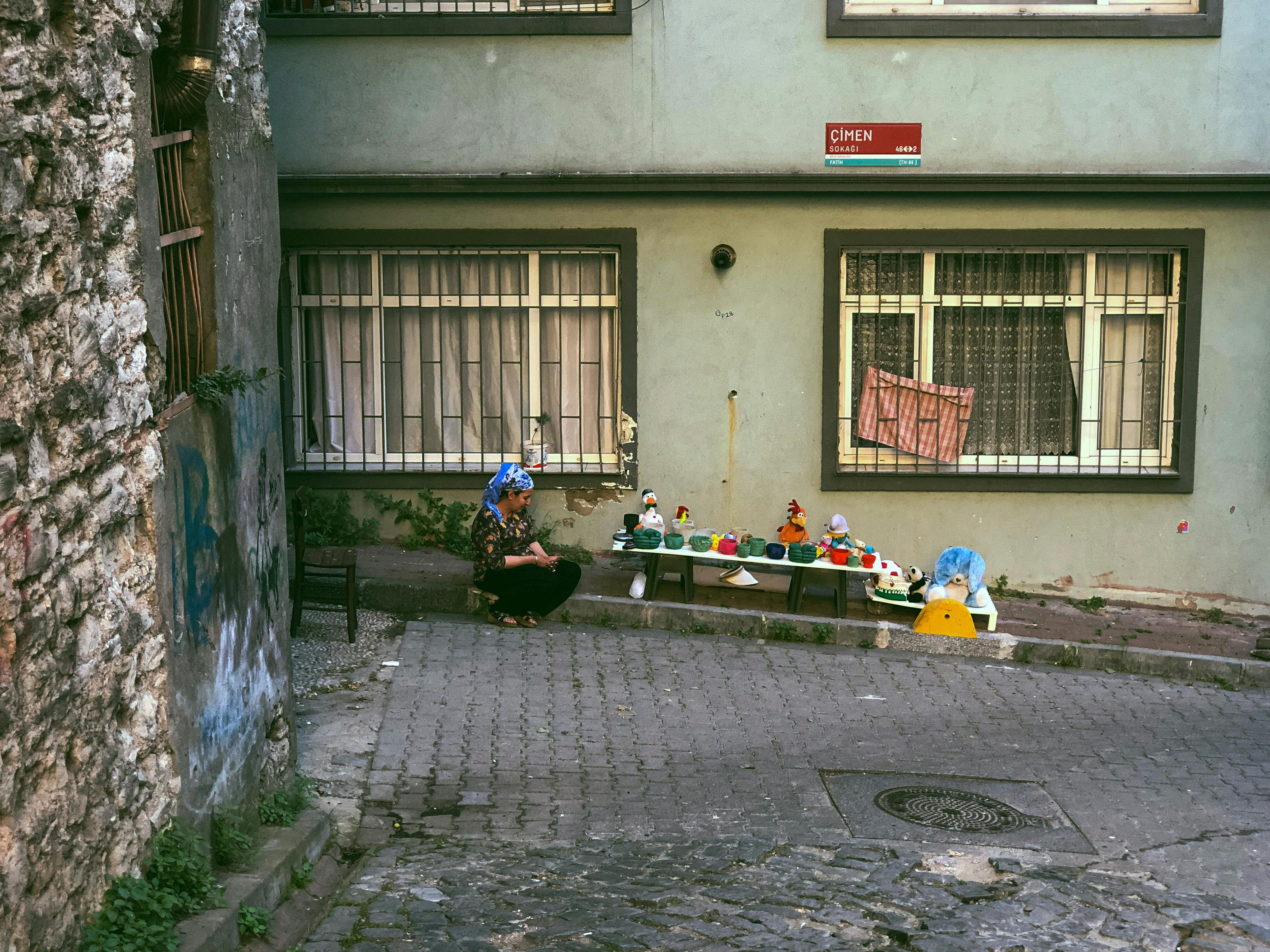 a woman sitting on a bench outside of a building