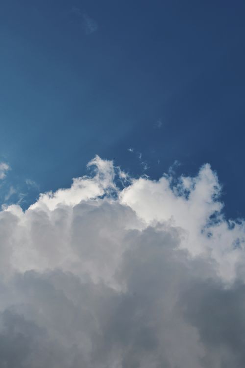 Free A vivid depiction of white clouds drifting in a clear blue sky, capturing a serene and airy summer day. Stock Photo