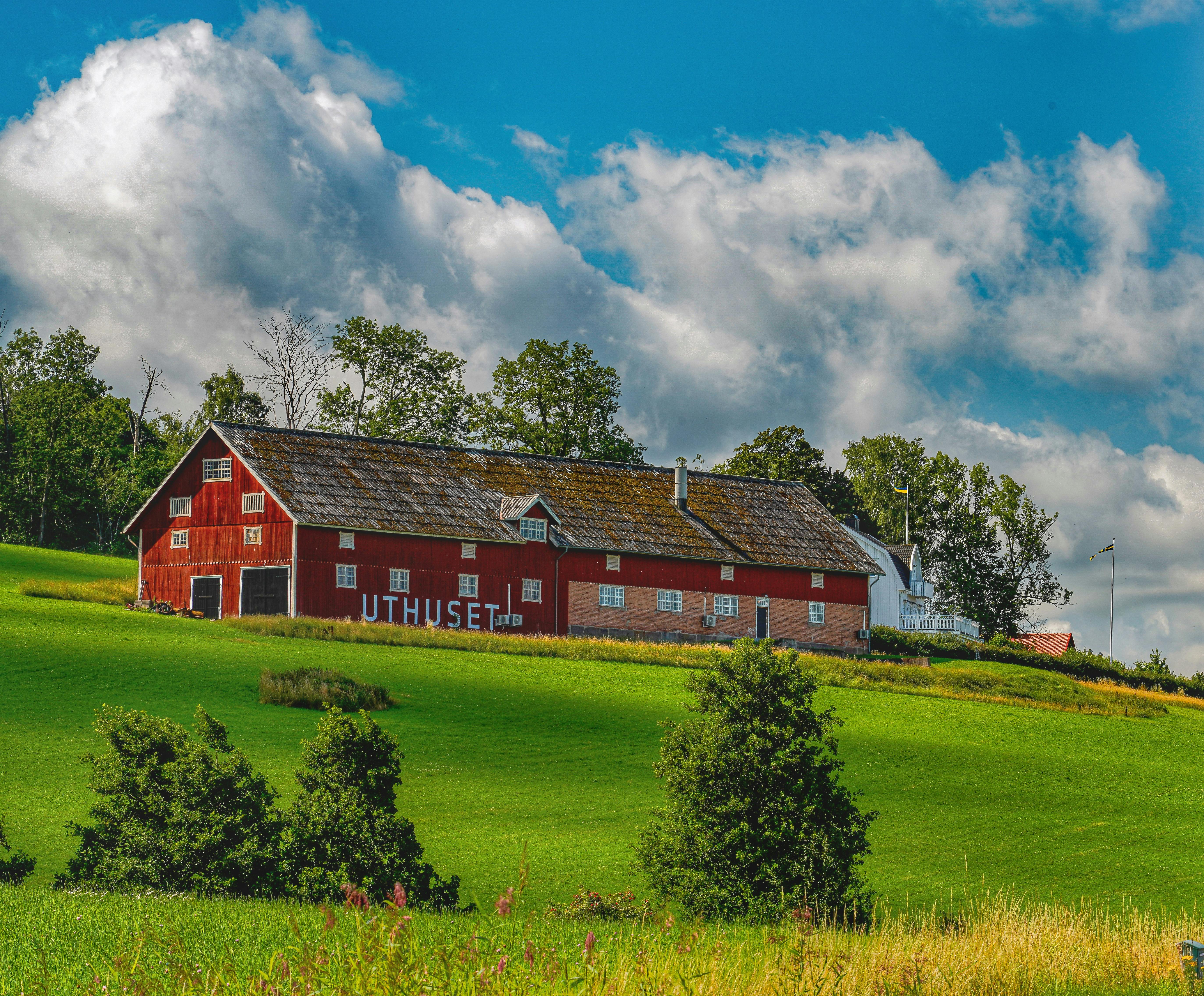 a red barn in a field with a blue sky