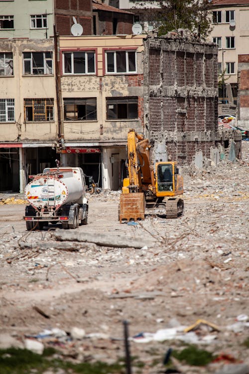 Free Excavator and truck working amidst urban ruins in Malatya, Türkiye. Stock Photo