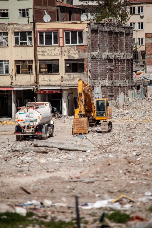 Free Excavator and truck working amidst urban ruins in Malatya, Türkiye. Stock Photo