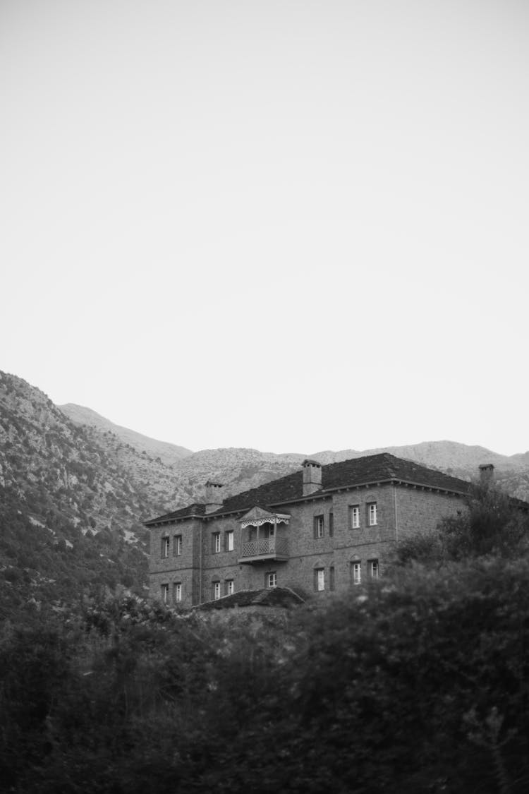 Black And White Photo Of A House In The Mountains