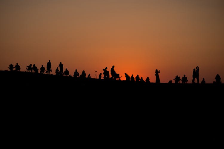 Silhouette Of People On A Desert During Sunset 