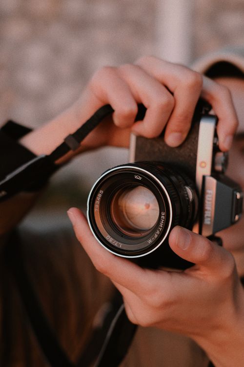 Free Close-up of hands holding a vintage camera, highlighting the classic lens. Stock Photo
