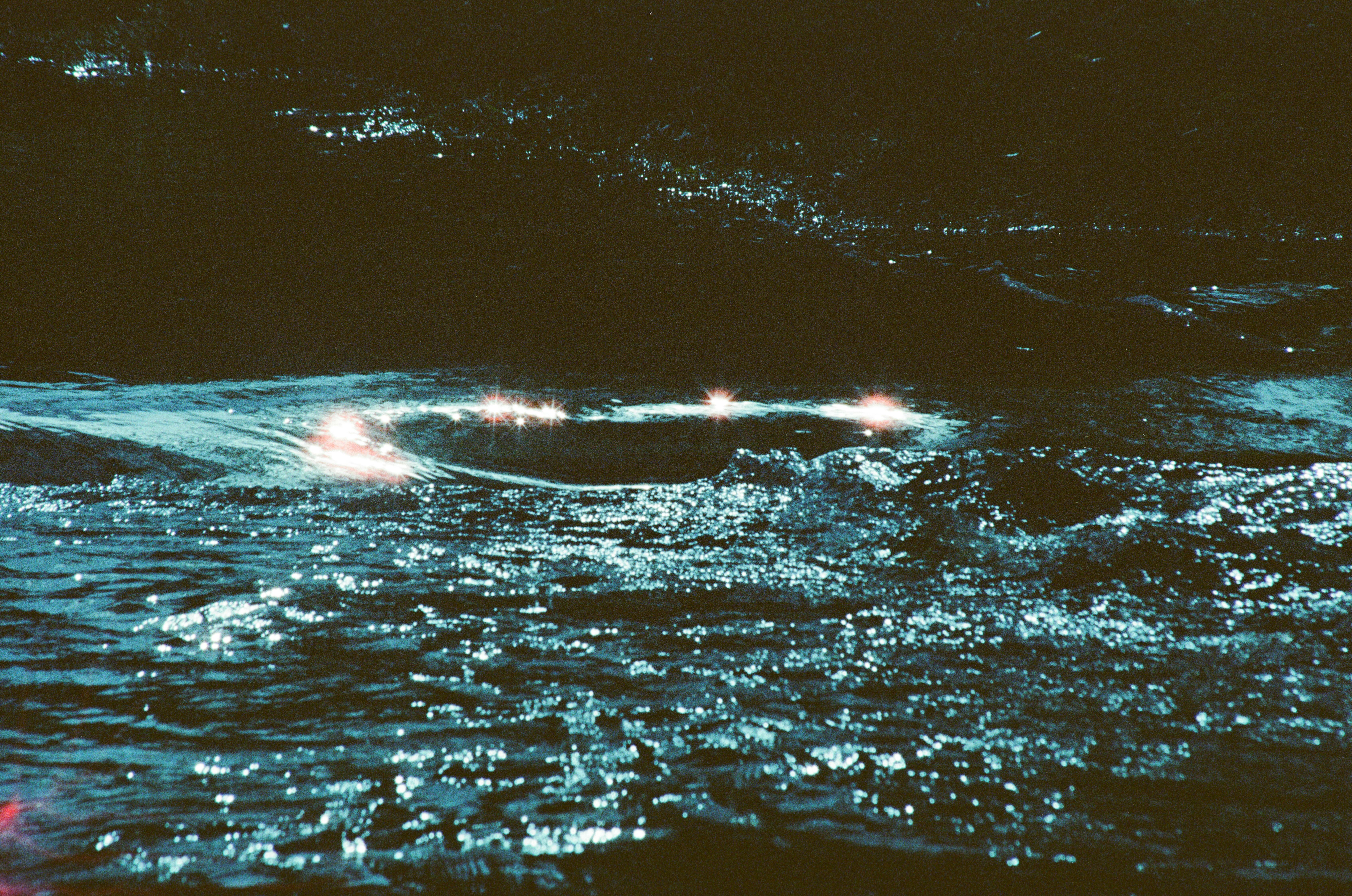 a boat is seen in the water at night