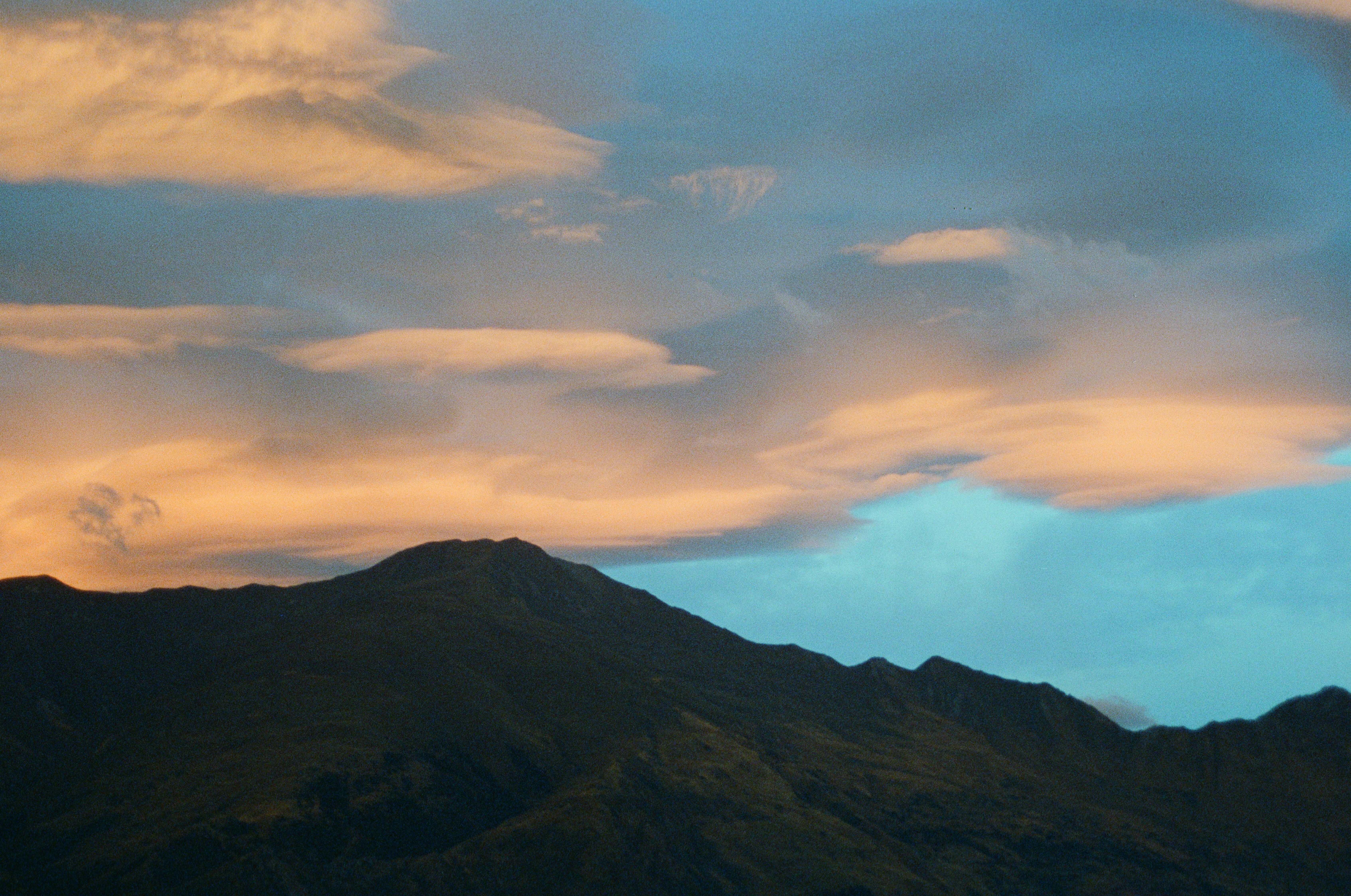 A mountain range with clouds in the sky · Free Stock Photo
