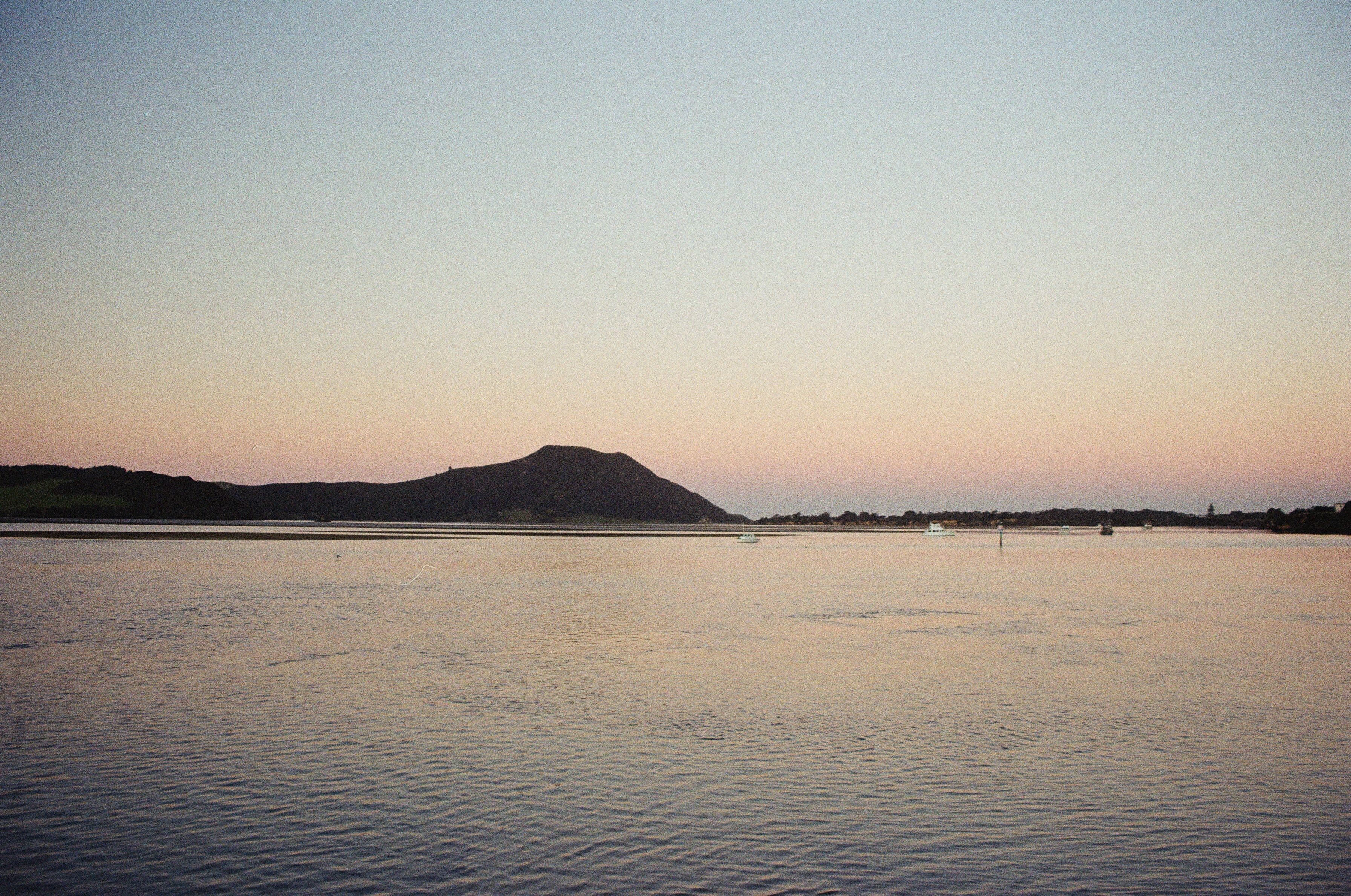 A body of water with a mountain in the distance · Free Stock Photo