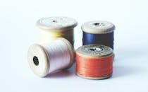 特写镜头下，复古木制线轴上缠绕的彩色缝纫线，非常适合工艺品项目