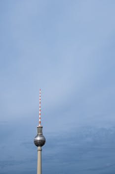 Iconic TV Tower in Berlin stands tall against a vast blue sky. Perfect aerial photography shot.
