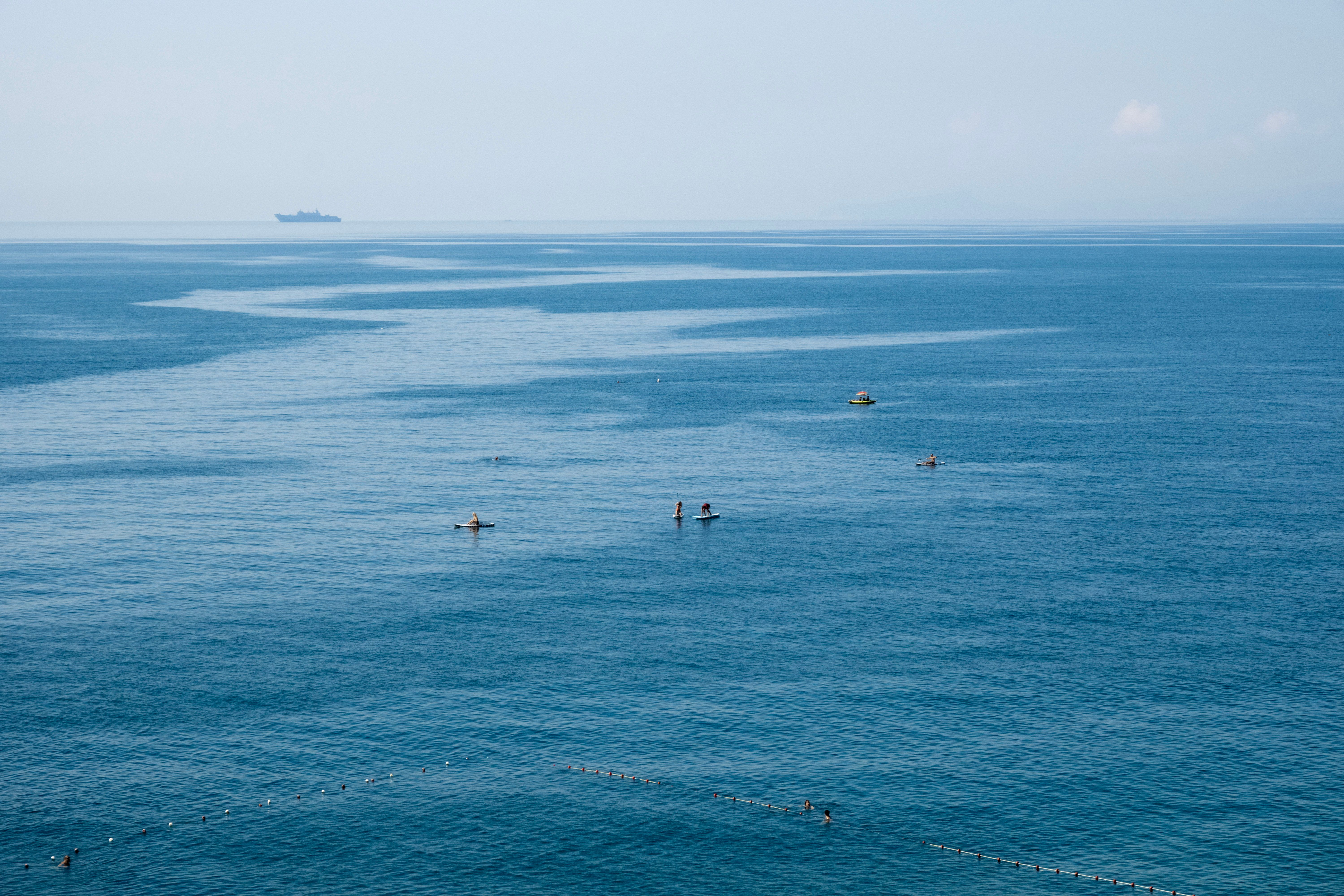 People on Surfboards Sailing in Sea
