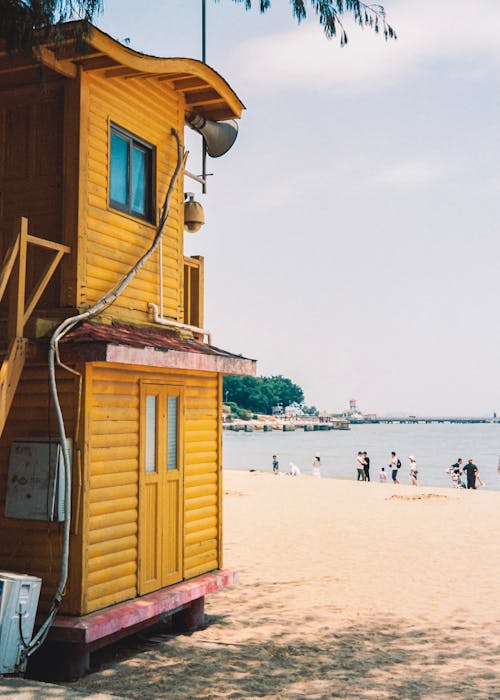 A yellow lifeguard tower on the beach