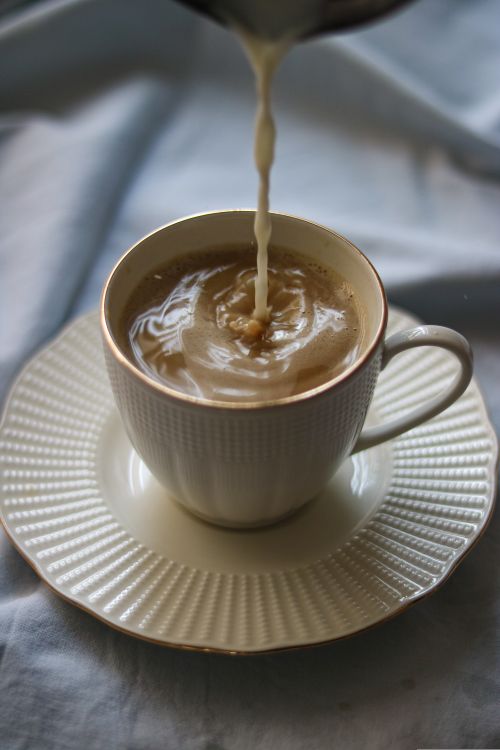 Free Capture the soothing swirl of cream mixing with coffee in an elegant cup. Stock Photo