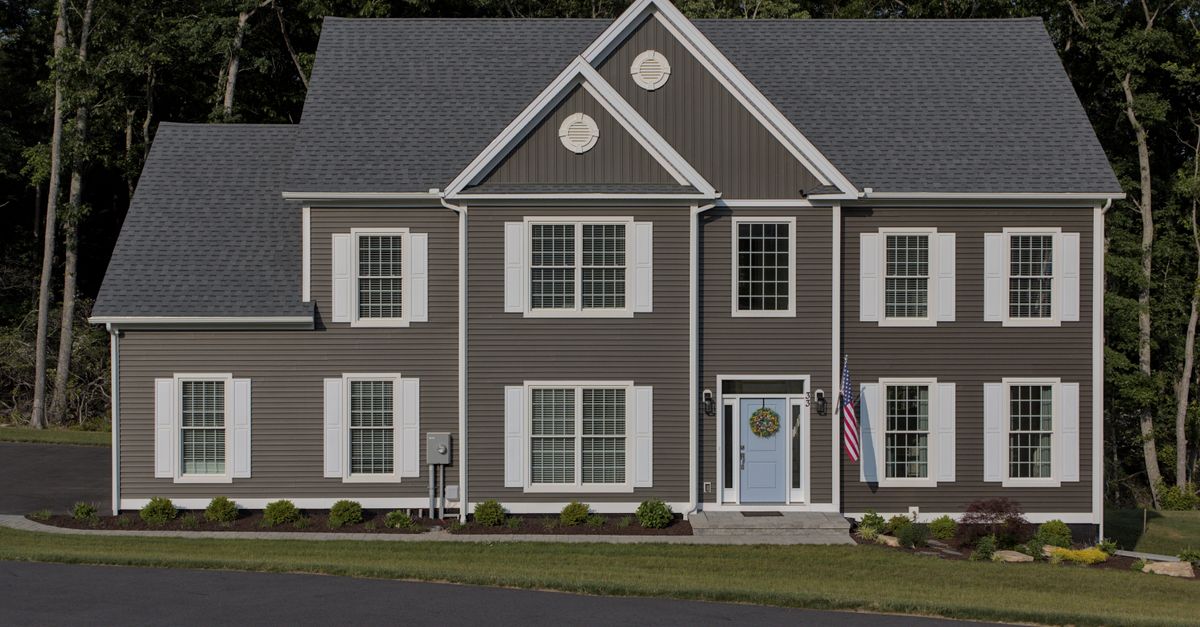 Front view of a classic suburban American house with manicured lawn and driveway.