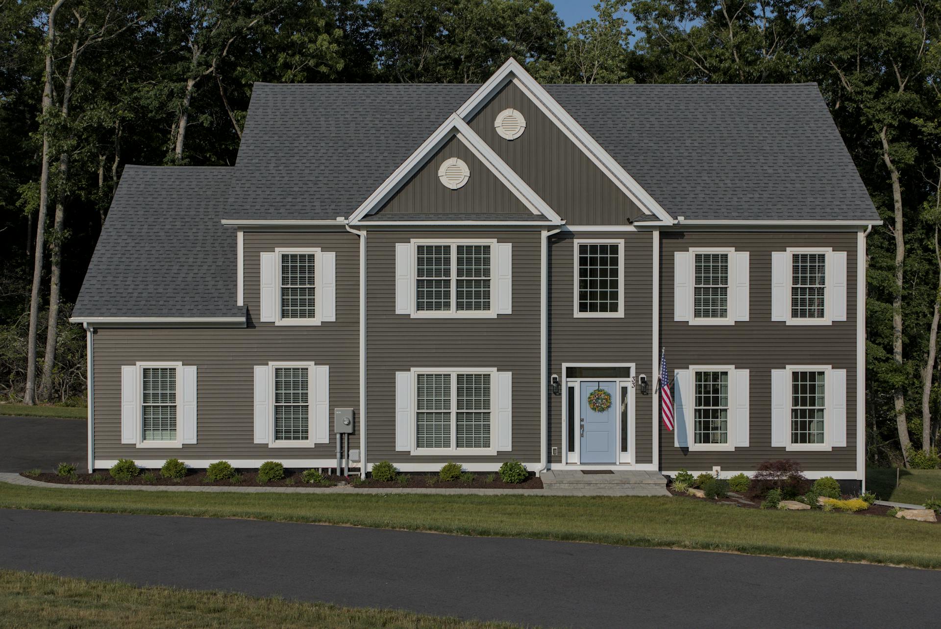 A gray house with white trim and gray siding