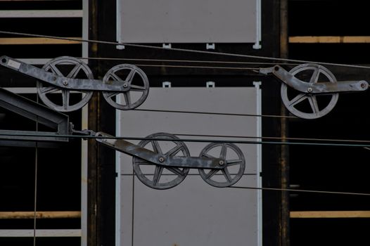 Detailed view of metallic pulleys on a modern building facade, capturing industrial design elements.