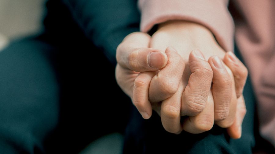 Two hands holding each other in support, symbolizing Mental Health Day awareness