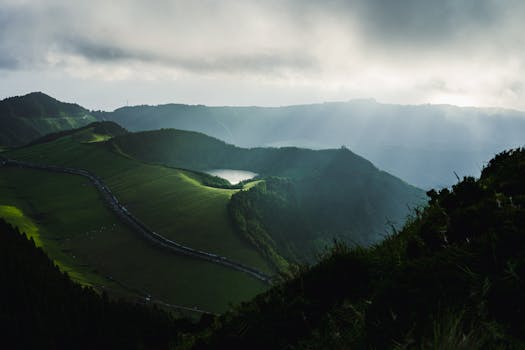 Breathtaking view of São Miguel, Azores with scenic mountains and sunlight streaming through clouds.