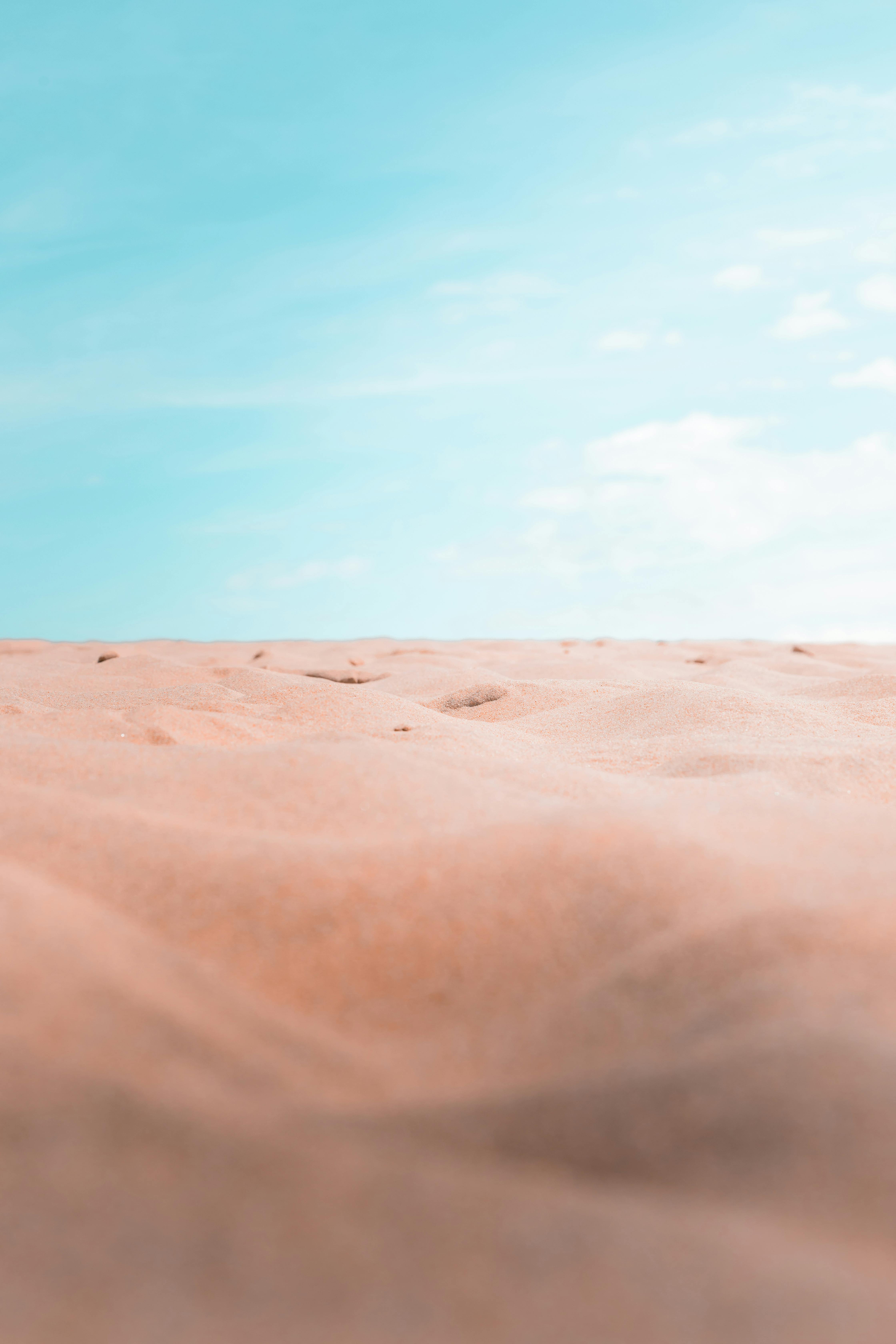 A sand dune with a blue sky in the background · Free Stock Photo