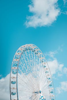 A large Ferris wheel in Bordeaux, France, set against a bright blue sky, capturing the essence of summer leisure.