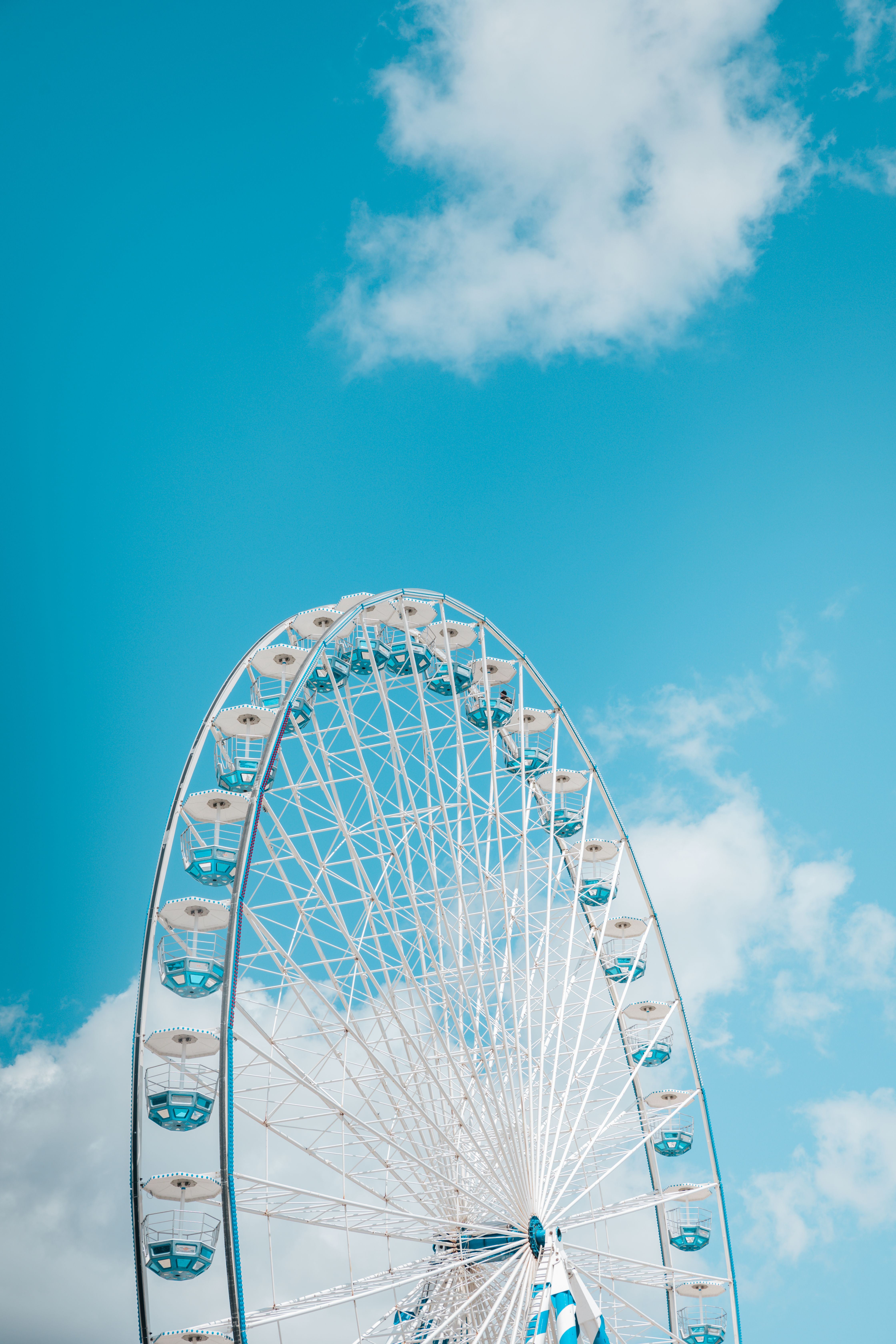 A ferris wheel against a blue sky and white clouds · Free Stock Photo