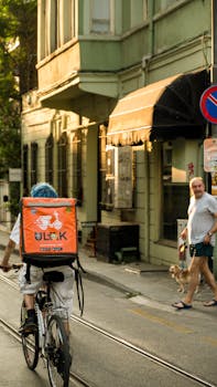 Bicycle delivery rider on city street during daytime in an urban setting.