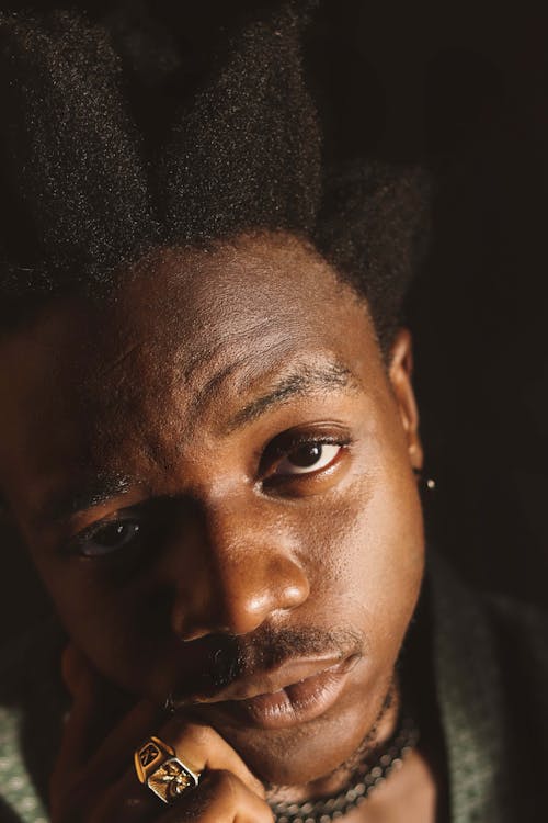 A young man with dreadlocks and a gold ring