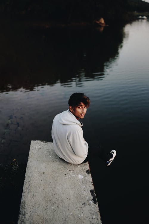 A Man Sitting by a Lake